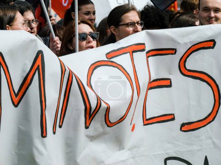 Foto de Strasborg, Francia - 29 de marzo de 2023: Un grupo multiétnico de adultos se para en protesta, chalecos amarillos y pancartas en alto contra la reforma de las pensiones del gobierno francés. Juntos marchan por un - Imagen libre de derechos