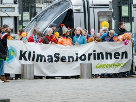 Photo for Strasbourg, France - Mar 29, 2023: A group of determined Swiss seniors peacefully protest in front of the European Court for Human Rights, holding placards as they demand action on climate change from - Royalty Free Image