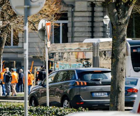 Foto de Strasborg, Francia - 29 de marzo de 2023: Visión general de la ciudad francesa con personas y automóviles y manifestantes en segundo plano - Francia experimenta semanas de protestas y huelgas relacionadas con un aumento de la pensión - Imagen libre de derechos