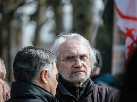 Téléchargez les photos : Strasbourg, France - 29 mars 2023 : Un homme âgé aux cheveux gris et une personne plus jeune discutent de la réforme des retraites. - en image libre de droit