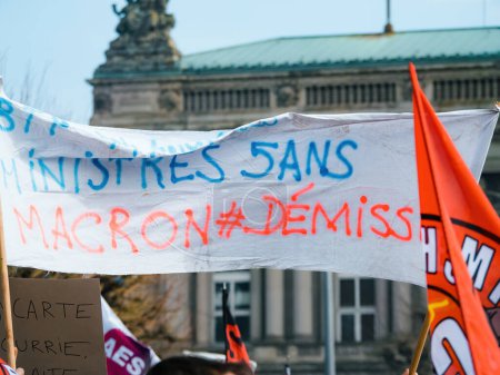 Téléchargez les photos : Strasbourg, France - 29 mars 2023 : Affiche Macron sur les congés - La France connaît des semaines de protestations et de grèves liées à la hausse de l "âge de la retraite, adoptée la semaine dernière - en image libre de droit