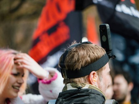 Téléchargez les photos : Strasbourg, France - 29 mars 2023 : L'arrière-plan d'un homme portant une caméra 360 sur la tête proteste contre la réforme des retraites à Strasbourg - en image libre de droit