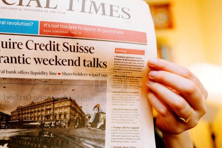 Photo for Paris, France - Mar 20, 2023: Close-up of Financial Times British newspaper breaking news of UBS historic acquisition of rival Credit Suisse Group AG - woman reading press in her living room with - Royalty Free Image