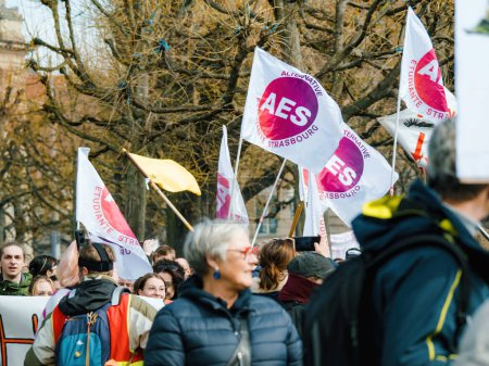 Téléchargez les photos : Strasbourg, France - 29 mars 2023 : Une foule nombreuse de manifestants, hommes et femmes, tiennent des pancartes exigeant des réformes de la part du gouvernement dans le cadre d'une grève nationale historique pour les droits à l'emploi. - en image libre de droit