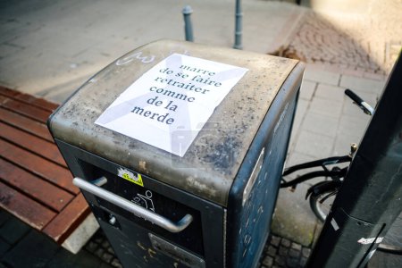 Foto de Estrasburgo, Francia - 20 de marzo de 2023: Pegatina en el cubo de basura dejado por los manifestantes contra la reforma de las pensiones en Estrasburgo Francia - Imagen libre de derechos