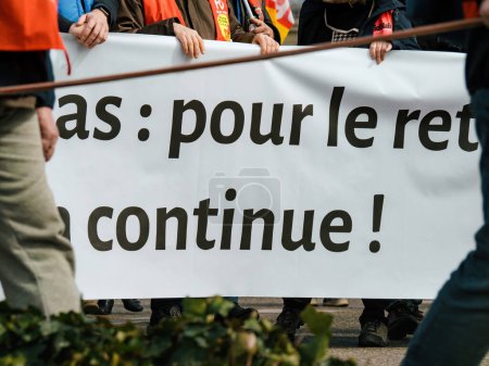 Photo for Strasborg, France - Mar 29, 2023: A large group of French protesters, men and women alike, are united in their nation-wide strike for pension reform. They hold placards with text as they rally - Royalty Free Image