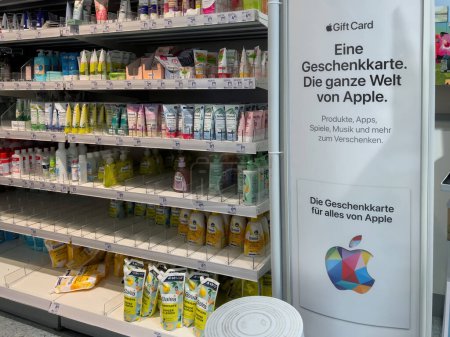 Téléchargez les photos : Francfort, Allemagne - 9 mars 2023 : Un stand de cartes-cadeaux Apple aux couleurs vives dans un magasin DM allemand, entouré de cosmétiques et d'autres produits. - en image libre de droit