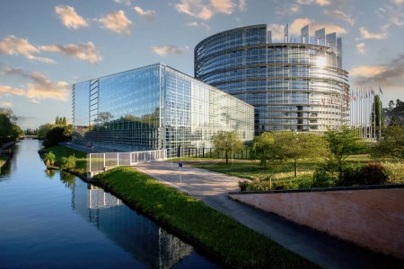 Foto de Estrasburgo, Francia - 23-abr-2017: Fantástica vista de la sede del Parlamento Europeo desde el puente Freedom con reflejo en el río Ill y todas las banderas de los miembros de la UE ondeando - Imagen libre de derechos