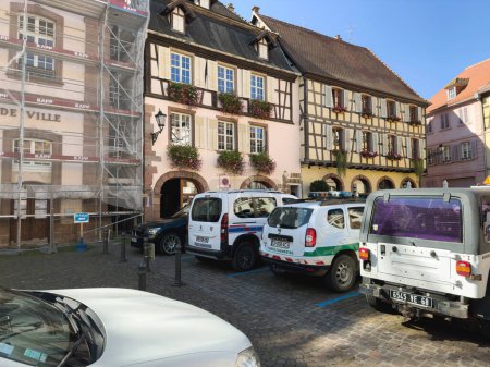 Photo for Ribeauville, France, Sep 22, 2022: The vibrant streets of Ribeauville, Alsace are bustling with cars ranging from Peugeots to Dacias. The city hall stands tall and proud near the parking lot. - Royalty Free Image