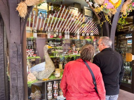 Foto de Ribeauville, Francia, 22 de septiembre de 2022: Una pareja de ancianos de Alsacia, Francia, explora las tiendas tradicionales y la cocina del pueblo mientras está de vacaciones.. - Imagen libre de derechos