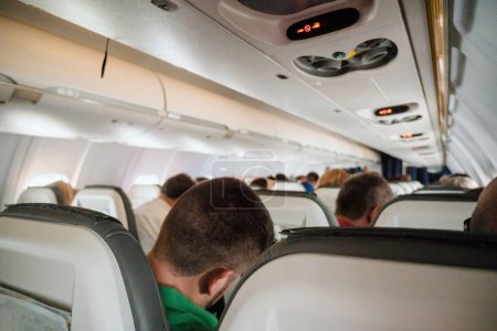 Téléchargez les photos : Un groupe de personnes profitant d'un voyage à l'intérieur spacieux d'un véhicule aérien, avec des sièges d'avion confortables - en image libre de droit