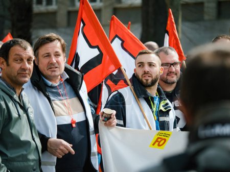 Foto de Strasborg, Francia - 29 de marzo de 2023: Un grupo de hombres adultos se une, sosteniendo una bandera en protesta contra el aumento de la edad de jubilación recientemente aprobada. Están marchando a través de Estrasburgo, Francia - Imagen libre de derechos