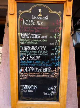 Foto de Ribeauville, Francia, 22-sep-2022: Menú de restaurante al aire libre con una selección de cerveza Lindemans belga, con precios escritos en una pizarra en escritura occidental. - Imagen libre de derechos