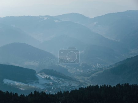 Foto de Una vista aérea de la hermosa Selva Negra en Alemania, llena de árboles de coníferas y niebla tranquila que crea un paisaje sereno desde el pico Feldberg - Imagen libre de derechos