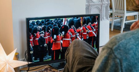 Téléchargez les photos : Paris, France - 6 mai 2023 : Une femme regarde attentivement Coldstream Guards célébrer le couronnement du roi Charles III et de la reine Camilla en Grande-Bretagne. - en image libre de droit