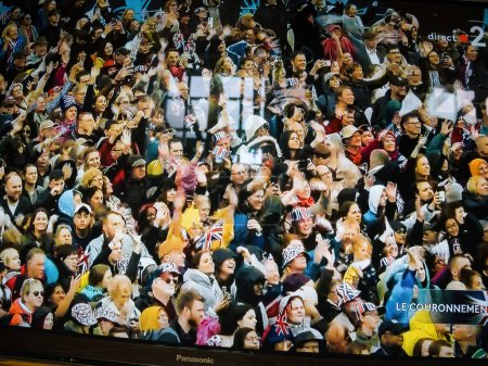 Téléchargez les photos : Paris, France - 6 mai 2023 : Une foule nombreuse se réunit pour assister au couronnement du roi Charles III et de la reine Camilla, retransmis en direct sur les chaînes d'information à travers le Royaume-Uni. - en image libre de droit