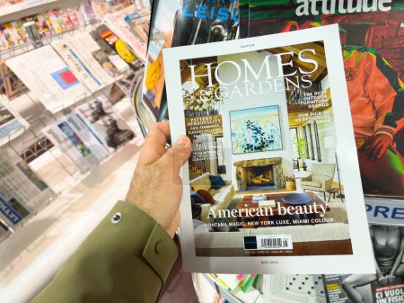 Photo for London, United Kingdom - 21 Apr 2023: A male hand holds a copy of the latest Homes and Gardens magazine, featuring an American Beauty-style cover. An embodiment of creative interior design mass media - Royalty Free Image