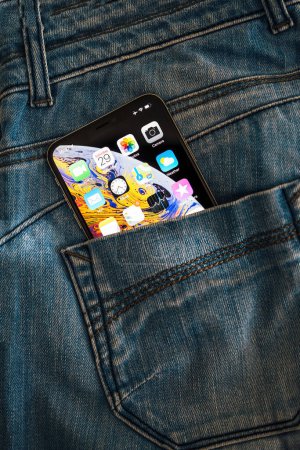 Foto de París, Francia - 29-sep-2018: Un bolsillo trasero de vaqueros tiene un nuevo smartphone Apple con pantalla OLED Retina, que muestra una multitud de aplicaciones. - Imagen libre de derechos