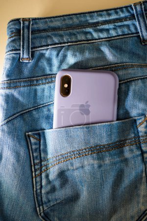 Foto de París, Francia - 29 de septiembre de 2018: Un iPhone de color dorado con una cámara doble, metido en el bolsillo trasero de los vaqueros. Un nuevo y elegante dispositivo Apple en un estilo icónico. - Imagen libre de derechos