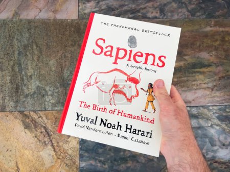 Photo for Paris, France - Apr 23, 2023: A male hand holds a book, Sapiens: A Graphic History of Humankind, written by the best-selling author Yuval Noah Harari. - Royalty Free Image