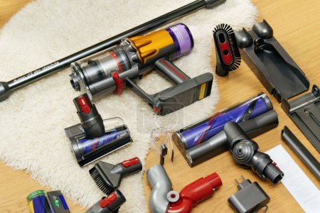 Photo for Paris, France - Jul 16, 2022: Lateral view knolling style above modern wireless Vacuum Cleaner powerful cordless colorful cyclonic dust collection - all accessories on the wooden parquet floor with - Royalty Free Image