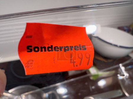 Téléchargez les photos : Un autocollant rouge vif avec un texte noir gras en allemand lit Sonderpreis 4,99 Euro - un prix spécial de seulement 4,99 euros - en image libre de droit