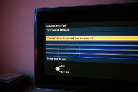 Photo for A modern TV set, showing a successful software download message in text. Ready to access air and satellite signals with an updated PCMCIA menu in blue - Royalty Free Image