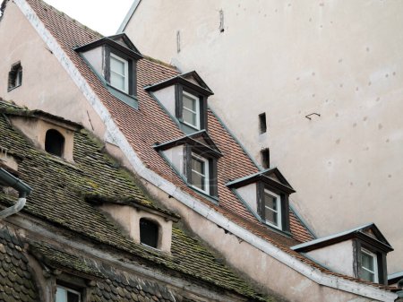 Foto de Un pintoresco barrio residencial en Estrasburgo, Francia, con edificios coloridos con aislamiento necesario y trabajos de reparación visibles en las ventanas vistas desde un ángulo bajo. - Imagen libre de derechos