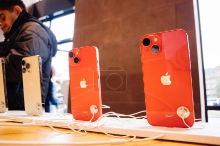 Téléchargez les photos : Paris, France - 22 sept. 2022 : Une rangée de nouveaux téléphones iPhone Pro 14 Max dans l'Apple Store, avec des clients en arrière-plan. Un objet iconique de héros technologique à l'intérieur. - en image libre de droit