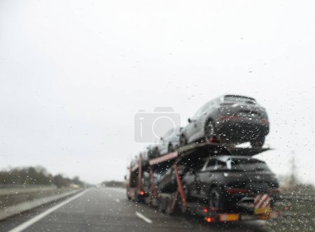 Photo for Driving on a wet highway with cargo on board, this vehicles windshield wiper clears the rain for a clearer view. Safe commuting, regardless of weather. - Royalty Free Image
