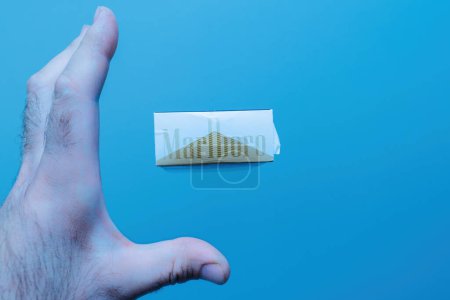 Photo for Paris, France - May 30, 2023: Someone is reaching for a Marlboro pack floating in the air against a blue background. A concerning commentary on unhealthy habits and tobacco use. - Royalty Free Image