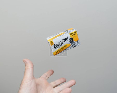 Photo for Paris, France - May 30, 2023: Levitating mid-air, Energizer AAA batteries above male hand - gray background - Royalty Free Image