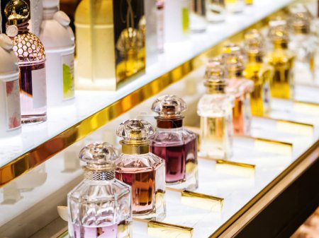Foto de Array de elegantes botellas de perfume de cristal en una fila, mostrando varios aromas de moda y aromas atractivos en una tienda de gama alta. - Imagen libre de derechos