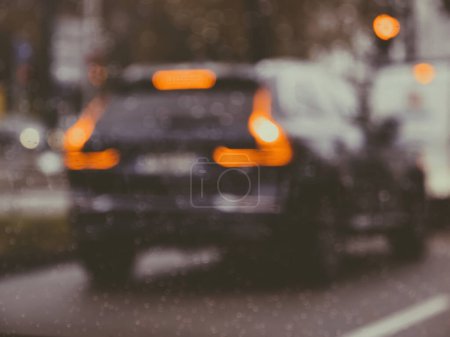 Photo for Rainy city street with blurred cars in motion, defocused view of vehicles and city life through wet windshield, showcasing transportation and traffic. - Royalty Free Image