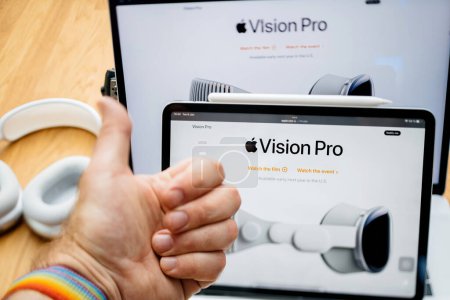 Photo for Paris, France - Jun 6, 2023: Thumb-up of the user over creative room table with webpage of Apple on iPad Pro showcasing Apple Vision Pro mixed reality XR headset. Priced 3,499 USD - future of - Royalty Free Image