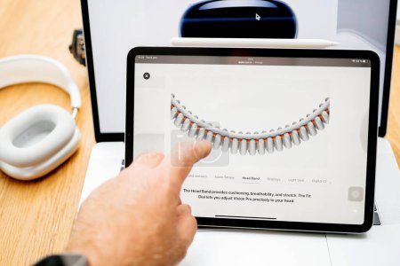 Foto de París, Francia - 6 de junio de 2023: Lectura manual sobre la nueva Head Band en la página web de Apple iPad Pro que muestra los auriculares XR de realidad mixta Apple Visión Pro. Precio 3,499 USD - futuro de la informática - Imagen libre de derechos