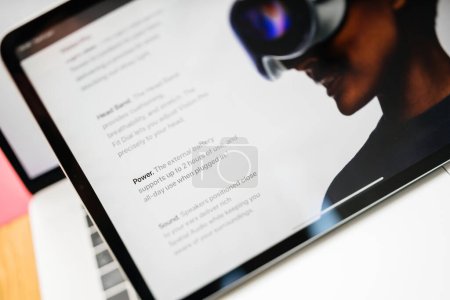 Téléchargez les photos : Paris, France - 6 juin 2023 : Texte basculant Alimentation et batterie externe supportent jusqu'à 2 heures d'utilisation - Table de salon créative avec page web d'Apple sur iPad Pro présentant Apple Vision Pro mixte - en image libre de droit