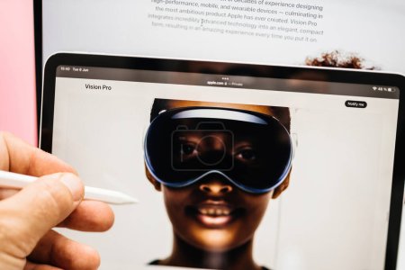 Photo for Paris, France - Jun 6, 2023: Hand holding pen above the Apple on iPad Pro showcasing Apple Vision Pro mixed reality XR headset. Priced 3,499 USD - future of computing - Royalty Free Image