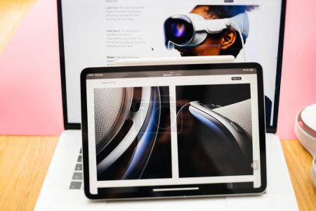 Photo for Paris, France - Jun 6, 2023: Fluid lines of the new device seen on the creative room table with webpage of Apple on iPad Pro showcasing Apple Vision Pro mixed reality XR headset. Priced 3,499 USD - - Royalty Free Image