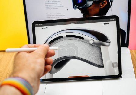 Photo for Paris, France - Jun 6, 2023: Hand with pencil scrolling reading webpage of Apple on iPad Pro showcasing Apple Vision Pro mixed reality XR headset. Priced 3,499 USD - future of computing - Royalty Free Image