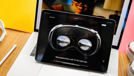 Photo for Paris, France - Jun 6, 2023: Ad text - More pixels than a 4K TV. For each eye. Creative room table with webpage of Apple on iPad Pro showcasing Apple Vision Pro mixed reality XR headset. Priced 3,499 - Royalty Free Image