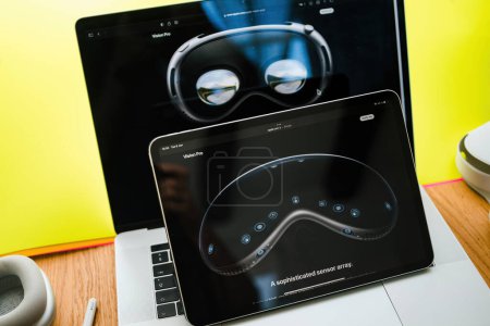 Foto de París, Francia - 6 de junio de 2023: Mesa de sala creativa con la página web de Apple en el iPad Pro que muestra los auriculares XR de realidad mixta Apple Visión Pro que muestran una sofisticada matriz de sensores para el mapeo 3D en tiempo real - Imagen libre de derechos