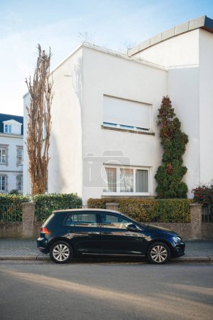 Téléchargez les photos : Strasbourg, France - 25 déc. 2015 : Un VW Golf stationné devant un magnifique bâtiment de la ville. La voiture allemande améliore la vue sur la maison et est un mode de transport pratique. - en image libre de droit