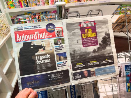 Photo for London, United Kingdom - 21 Apr 2023: POV male hand holding at press kiosk latest newspapers of Aujordhui and Liberation magazine featuring on the cover latest French news - Royalty Free Image