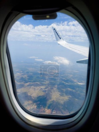 Foto de Mallorca, España - 22 de junio de 2023: Sobre Mallorca, una perspectiva aérea captura la belleza escénica y la inmensidad del cielo a través de un ojo de buey de avión - Imagen libre de derechos