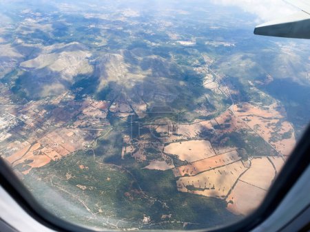 Foto de Vista aérea captura exuberantes tierras de cultivo de Mallorca, España. Paisaje sereno de la naturaleza visto a través de ventana transparente. - Imagen libre de derechos