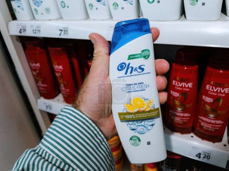 Téléchargez les photos : Mallorca, Espagne - 28 juin 2023 : Un homme POV tenant une main achetant un shampooing frais aux agrumes H et S dans un supermarché espagnol - en image libre de droit