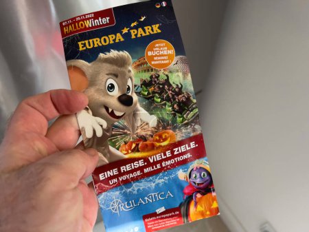Photo for Frankfurt, Germany - Feb 21, 2023: POV male hand holding flyer with Europa Park adventures schedules - Royalty Free Image