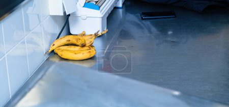 Foto de Una colorida variedad de plátanos adorna una cocina de acero inoxidable, preparando el escenario para una deliciosa comida. - Imagen libre de derechos