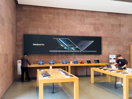 Foto de Estrasburgo, Francia - 10 de julio de 2023: Interior de la tienda Apple Computers con dispositivos Genius worker y Aplle Computes - iPad y anuncio para el nuevo MacBook Pro - Imagen libre de derechos